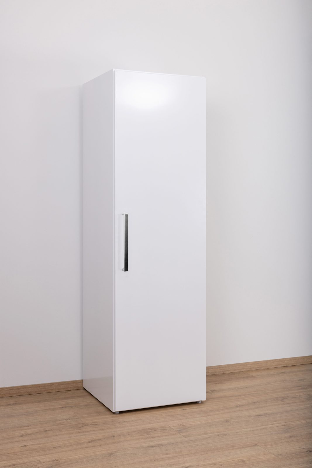 Een witte koelkast in een lege keuken op het werk.