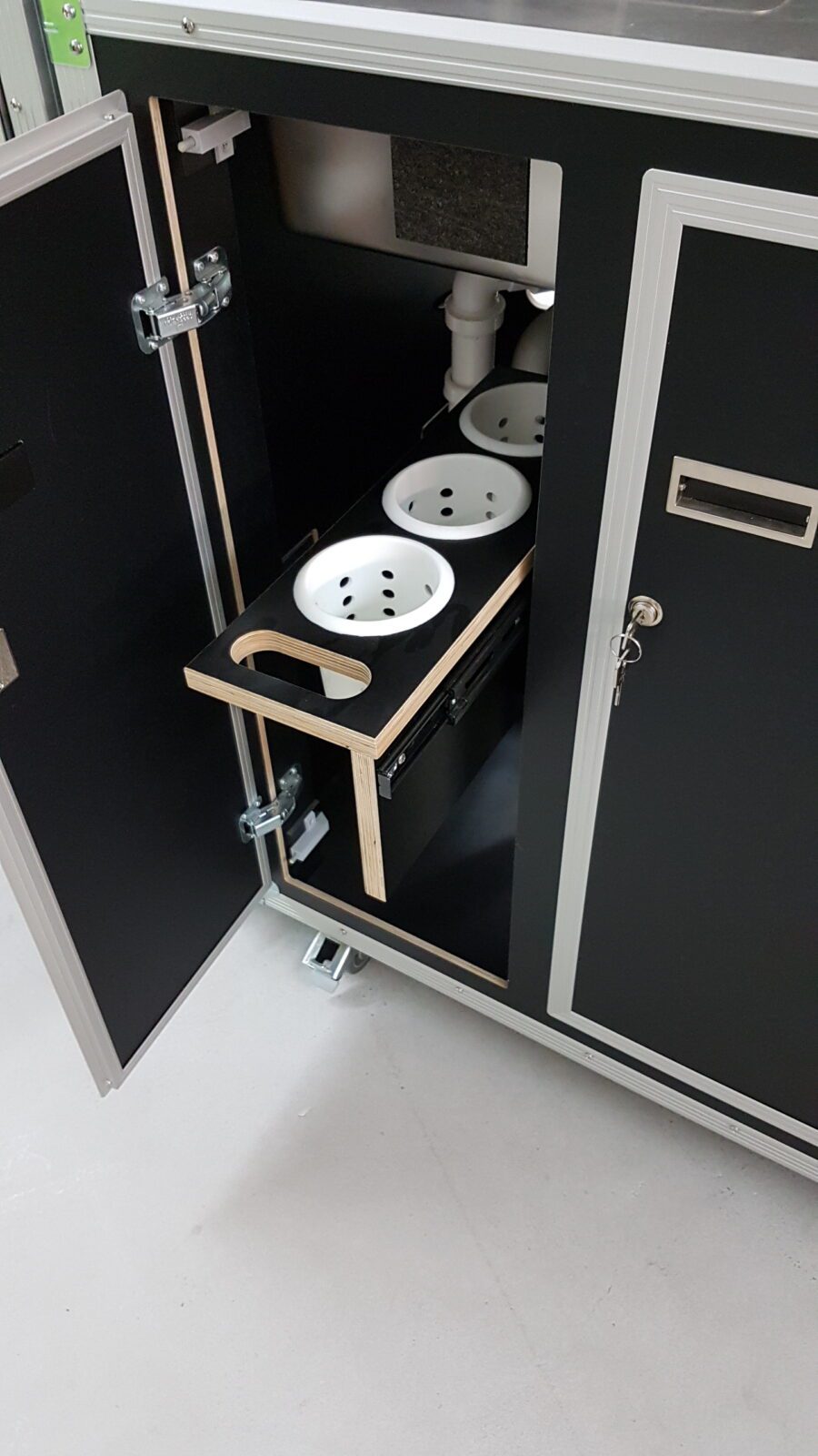 Een zwarte kast met twee kommen erin geschikt voor Keuken huren in een flightcase | Compacte koffer 500 | Huurperiode 5 dagen gebruik.