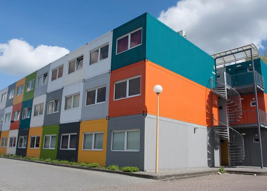 Een veelkleurig gebouw in Nijkerk met trappen aan de zijkant, met daarin een keuken op het werk.