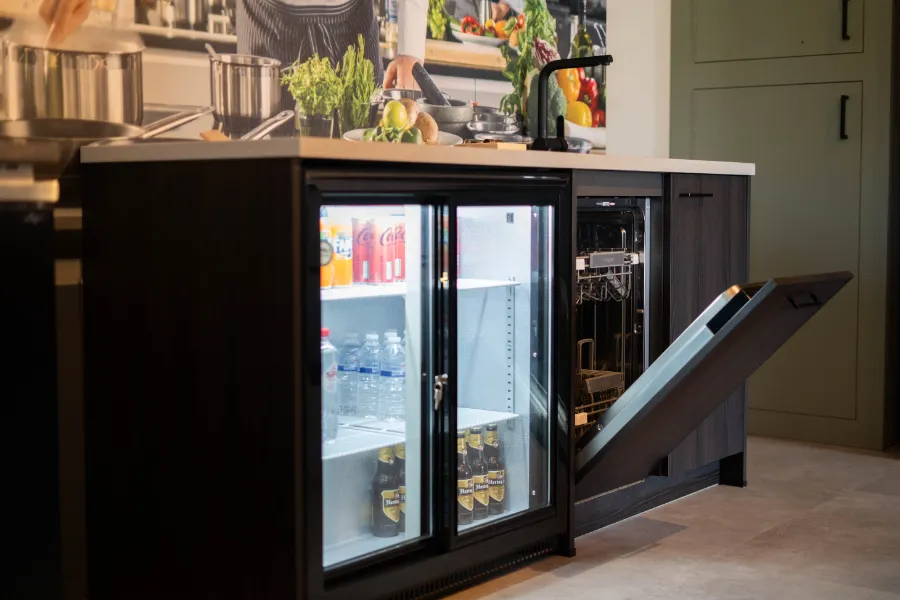 Een koelkast in een keuken op het werk met een deur open.