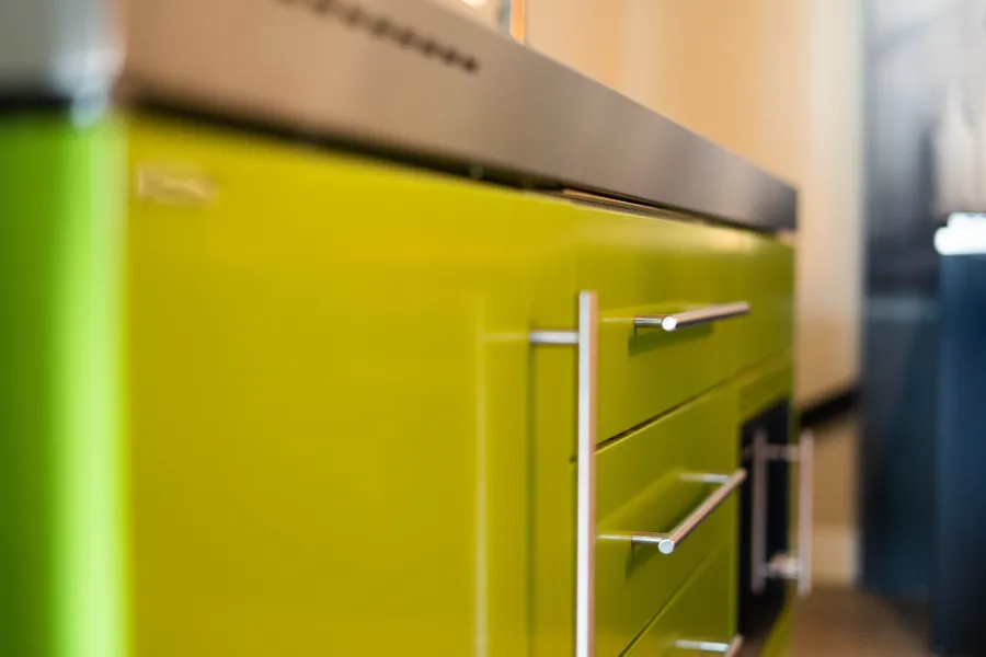 Een close-up van een groene keukenkast in een keuken-kantooromgeving.