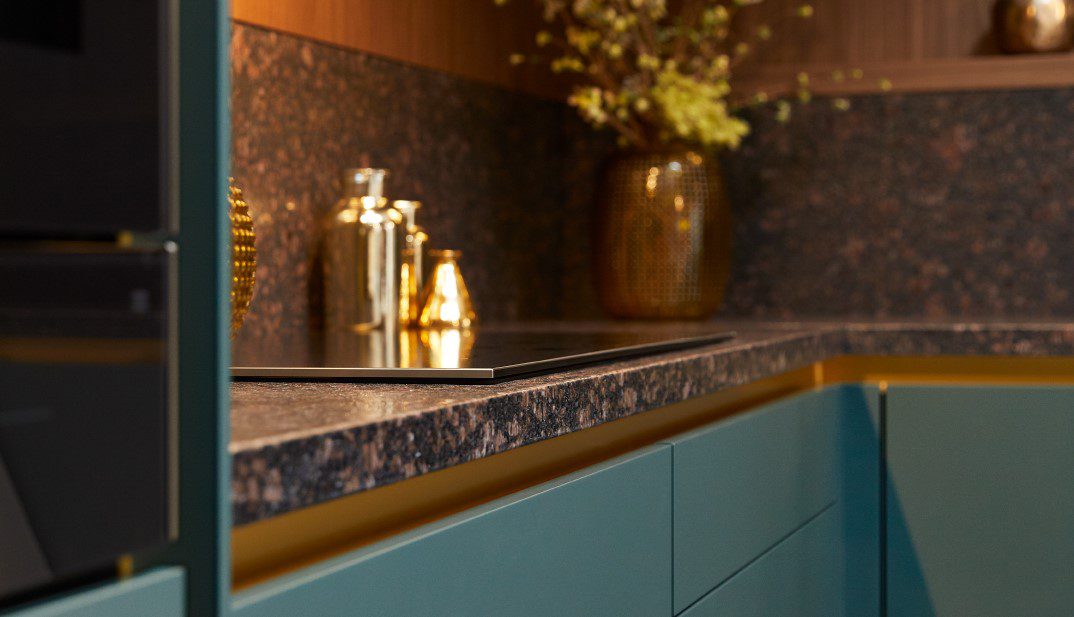 Een keuken met blauwe kasten en gouden apparaten.